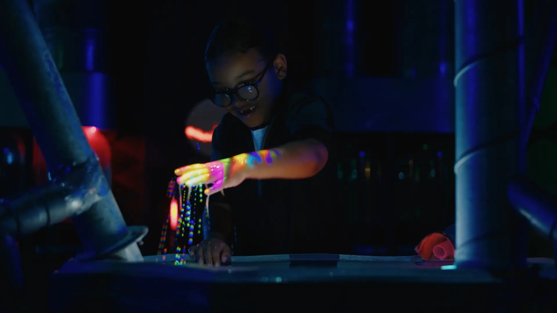 Close-up of projected colour currents moving across the white-pigment water surface in the mixing pool