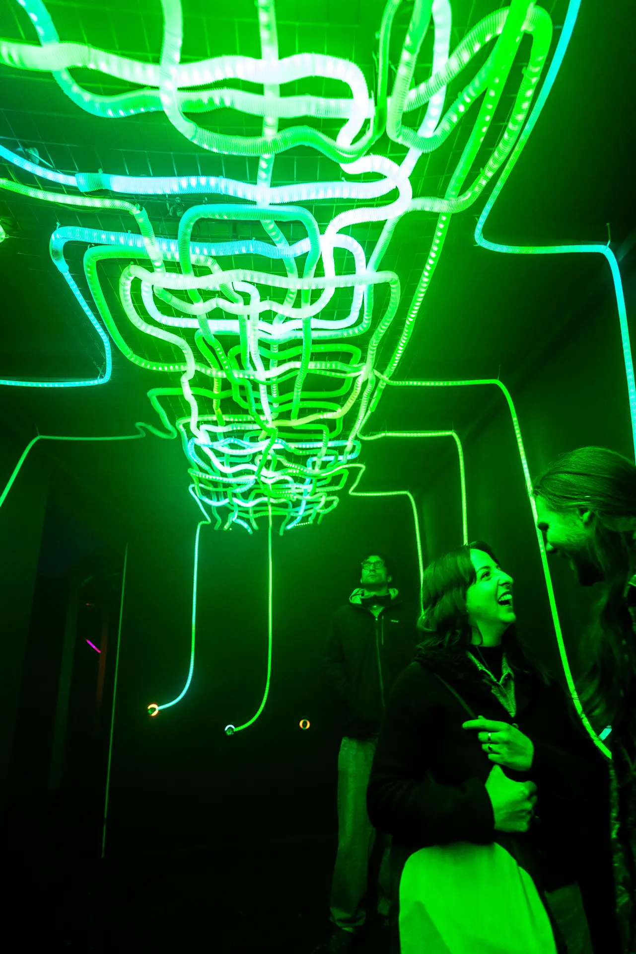 Close-up of a visitor guiding a glowing cable toward a magnetic socket