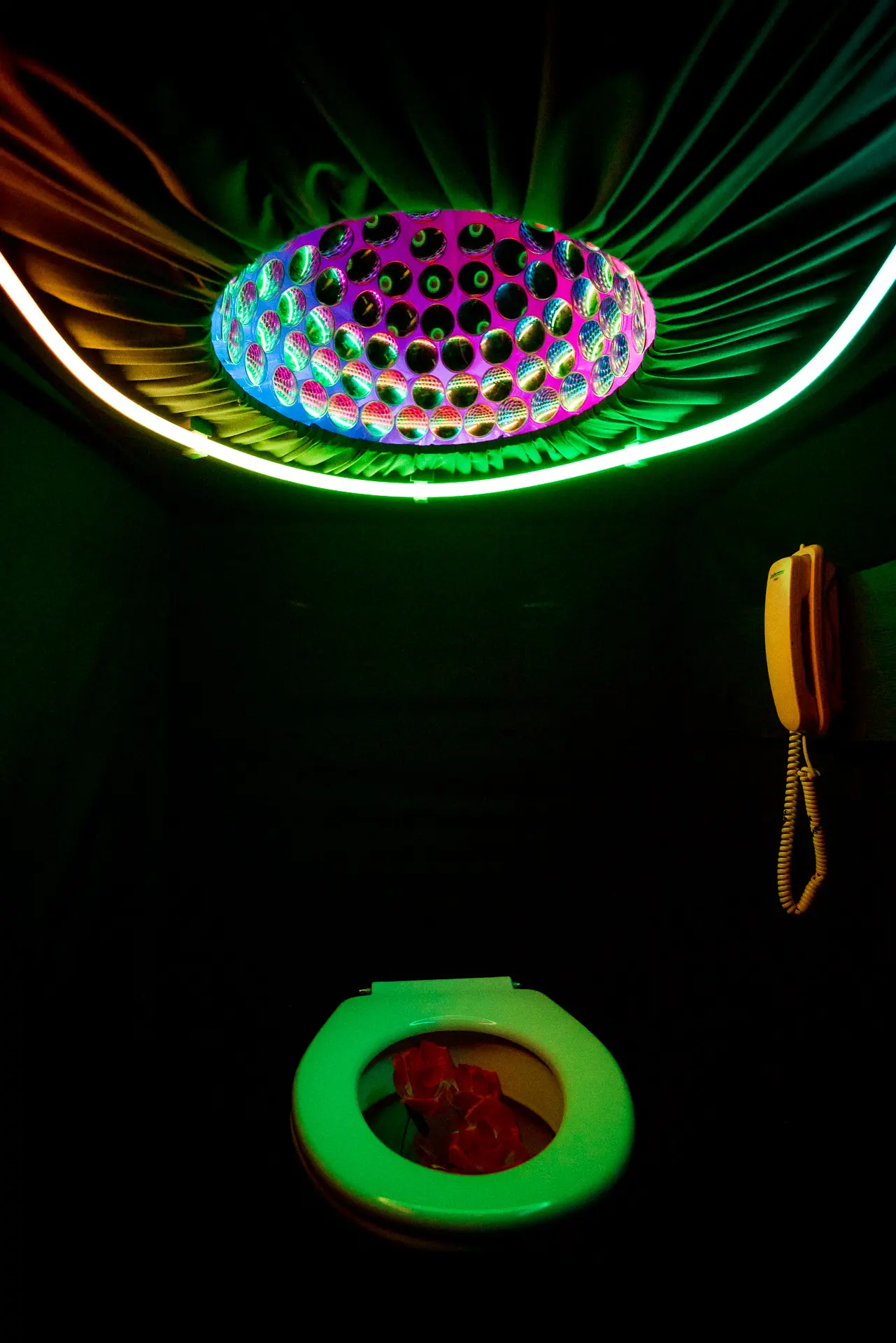 Portrait of a participant holding a handset while the environment responds with coloured light