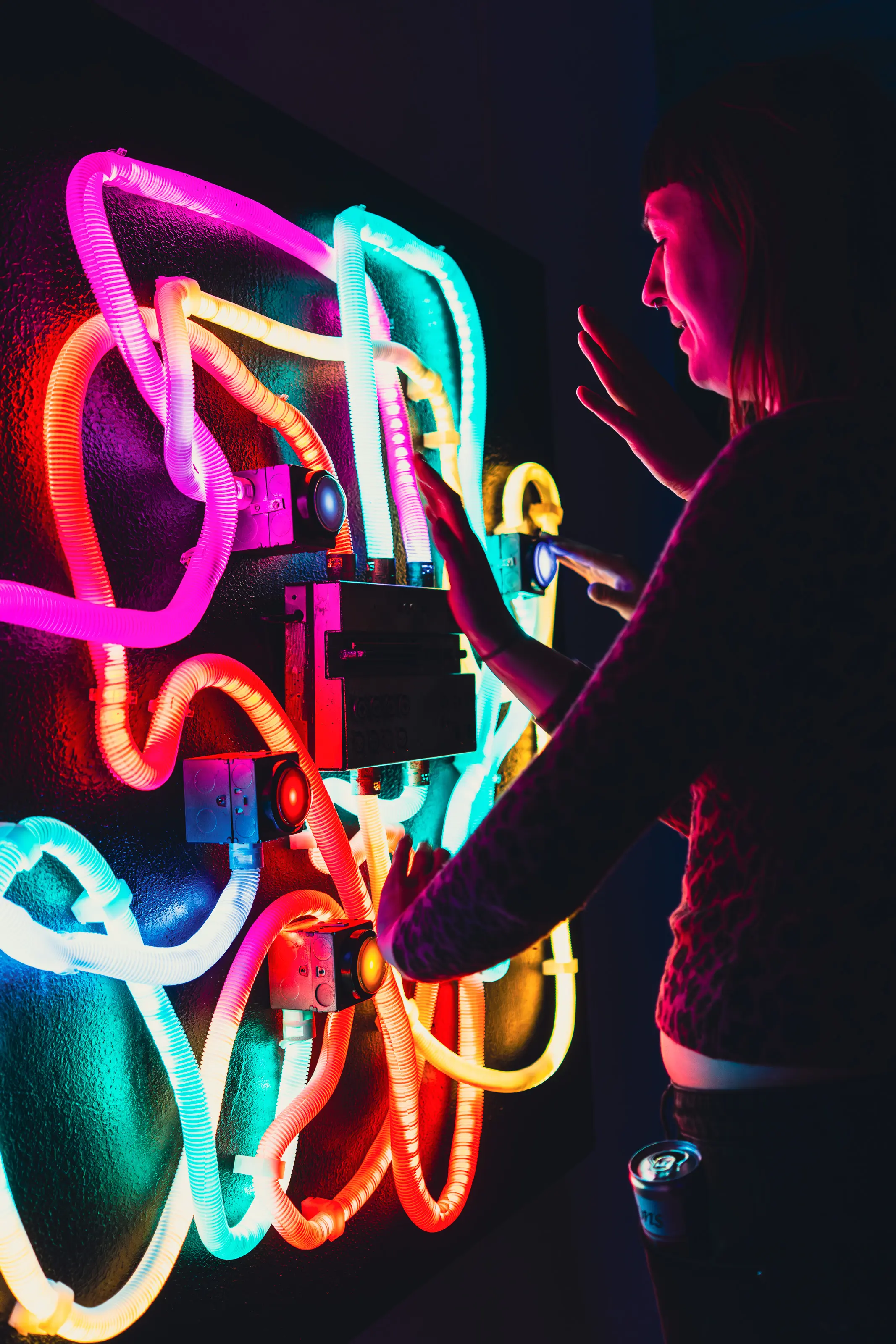 Portrait shot of a participant engaging with a responsive installation under pink and blue lighting