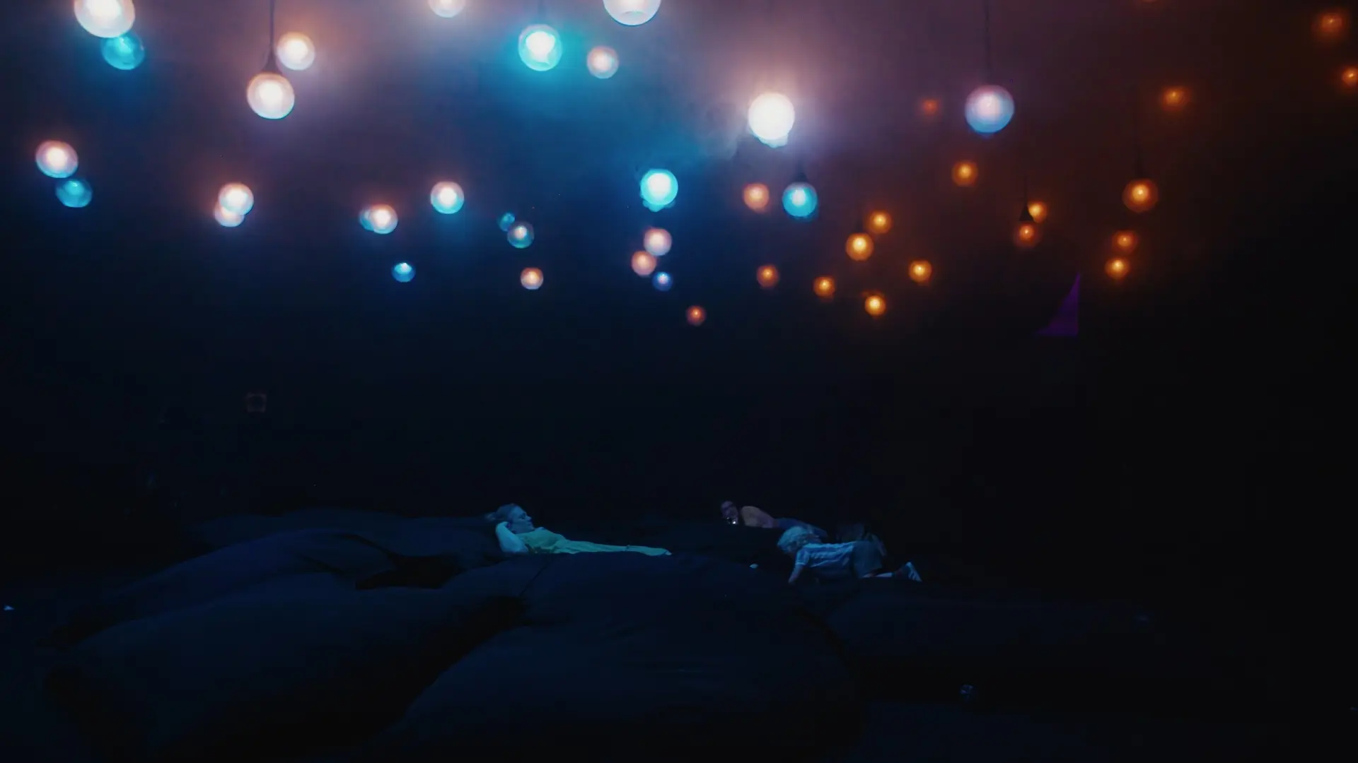 Overhead network of transparent tubes carrying coloured balls through the Scatter installation